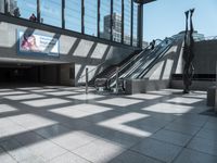 a building with an escalator and stairs near the entrance to a building with windows and large glass windows