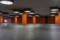 an empty building with lots of tall and wide orange pillars on each side of the walls