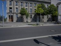 a person is standing in the middle of the street in front of the building and has two skateboards