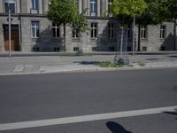 a person is standing in the middle of the street in front of the building and has two skateboards
