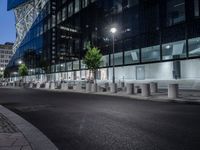 two large steel cylinders line an empty city street at night - looking like they could be smoking