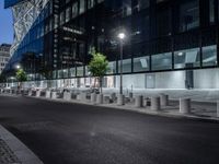 two large steel cylinders line an empty city street at night - looking like they could be smoking