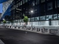 two large steel cylinders line an empty city street at night - looking like they could be smoking