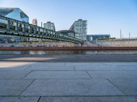 a skateboarder riding on a cement ramp next to a city street under a bridge