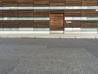 an image of a building with wooden walls and a street light on the curb with a bike attached to it