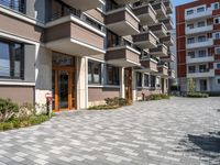 a building with the doors open, a brick floor and a parking area in front of it