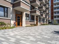 a building with the doors open, a brick floor and a parking area in front of it