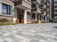 a building with the doors open, a brick floor and a parking area in front of it