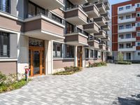 a building with the doors open, a brick floor and a parking area in front of it