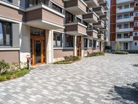 a building with the doors open, a brick floor and a parking area in front of it