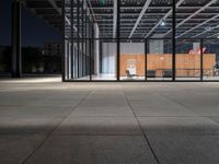 a chair inside of a building with glass walls on top of it and lots of wood