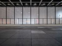 empty space with glass and steel walls with light reflecting in the window panes and floor tiles