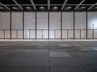 empty space with glass and steel walls with light reflecting in the window panes and floor tiles