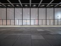 empty space with glass and steel walls with light reflecting in the window panes and floor tiles