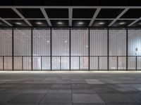 empty space with glass and steel walls with light reflecting in the window panes and floor tiles