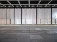 empty space with glass and steel walls with light reflecting in the window panes and floor tiles