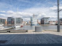 a very big building with a lot of boats near it by the water and some buildings