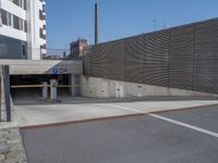 a street with a few buildings and concrete walls that have been painted yellow and black