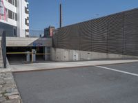 a street with a few buildings and concrete walls that have been painted yellow and black