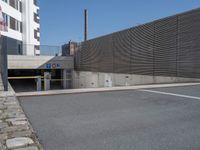 a street with a few buildings and concrete walls that have been painted yellow and black