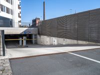 there is a car going under an overpass in the city street and there are stone walls