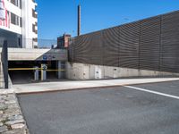 there is a car going under an overpass in the city street and there are stone walls