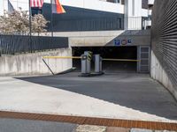 a parking garage in a building with the door open to the inside, at the end, there are barriers and several signs on it