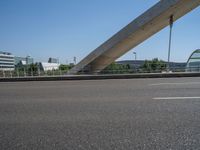 a truck driving across a bridge near a street corner near buildings and a bridge with many cables