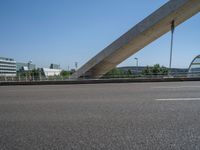 a truck driving across a bridge near a street corner near buildings and a bridge with many cables