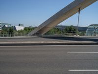 a truck driving across a bridge near a street corner near buildings and a bridge with many cables