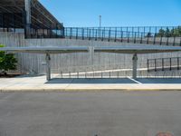 a pedestrian overpass with steps on both sides and one going up the side to the other