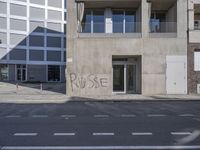 there is a graffiti written on the side of a building in this street corner that reads rude