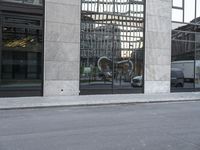 the black car is parked at the curb of a large building in the city center