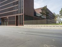 there is a large building on the other side of the street in this shot from the left of the road