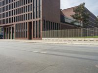 there is a large building on the other side of the street in this shot from the left of the road