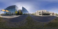 a distorted image shows the intersection of a street and a skyscraper building with several cars