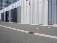 there is a brick walkway outside a building on this street with white fence and concrete curbes