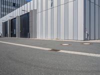 there is a brick walkway outside a building on this street with white fence and concrete curbes