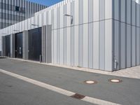 there is a brick walkway outside a building on this street with white fence and concrete curbes