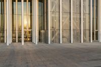 a bench that is in front of a large glass wall next to a building with people