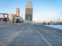 a building near the ocean with a bridge above it on a cobble stone walkway