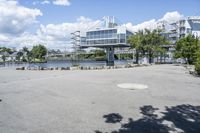 there is a large white building that is next to a body of water with some trees in the foreground