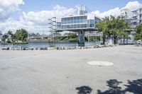 there is a large white building that is next to a body of water with some trees in the foreground