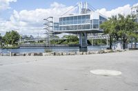 there is a large white building that is next to a body of water with some trees in the foreground