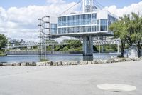 there is a large white building that is next to a body of water with some trees in the foreground