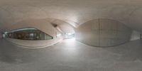 a fish eye view of a building from inside a very long tunnel, looking out