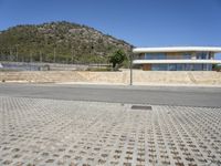 a large building with an open courtyard and paved walkways leading to it in front of a mountain