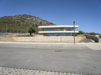 a large building with an open courtyard and paved walkways leading to it in front of a mountain