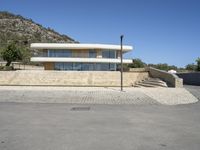 a large building with an open courtyard and paved walkways leading to it in front of a mountain