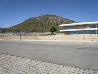 a large building with an open courtyard and paved walkways leading to it in front of a mountain